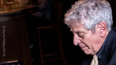 Man in suit and tie playing piano