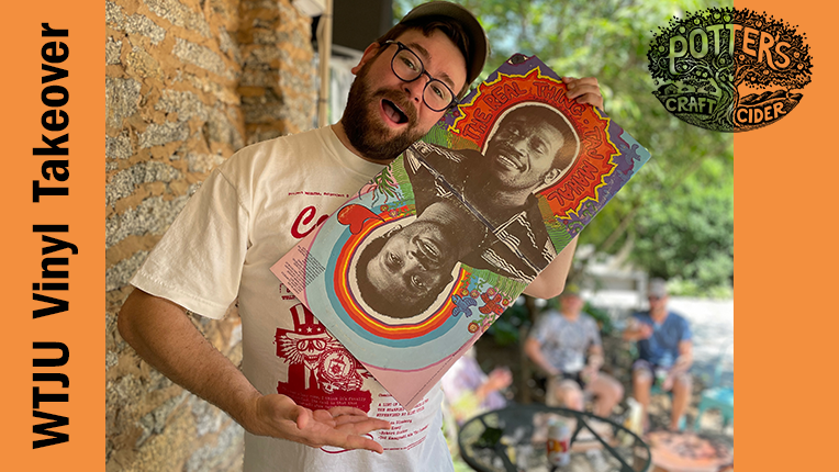 A man in a white shirt holds a colorful vinyl record cover