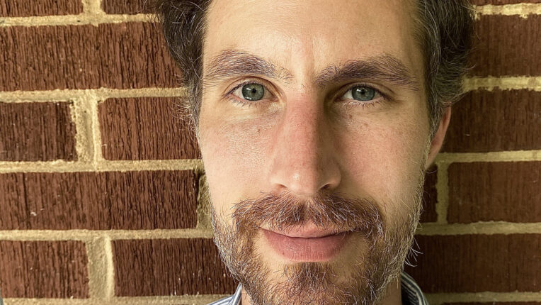 Person with beard with brick wall behind