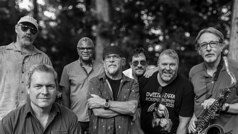black and white image of seven men gathered together outside
