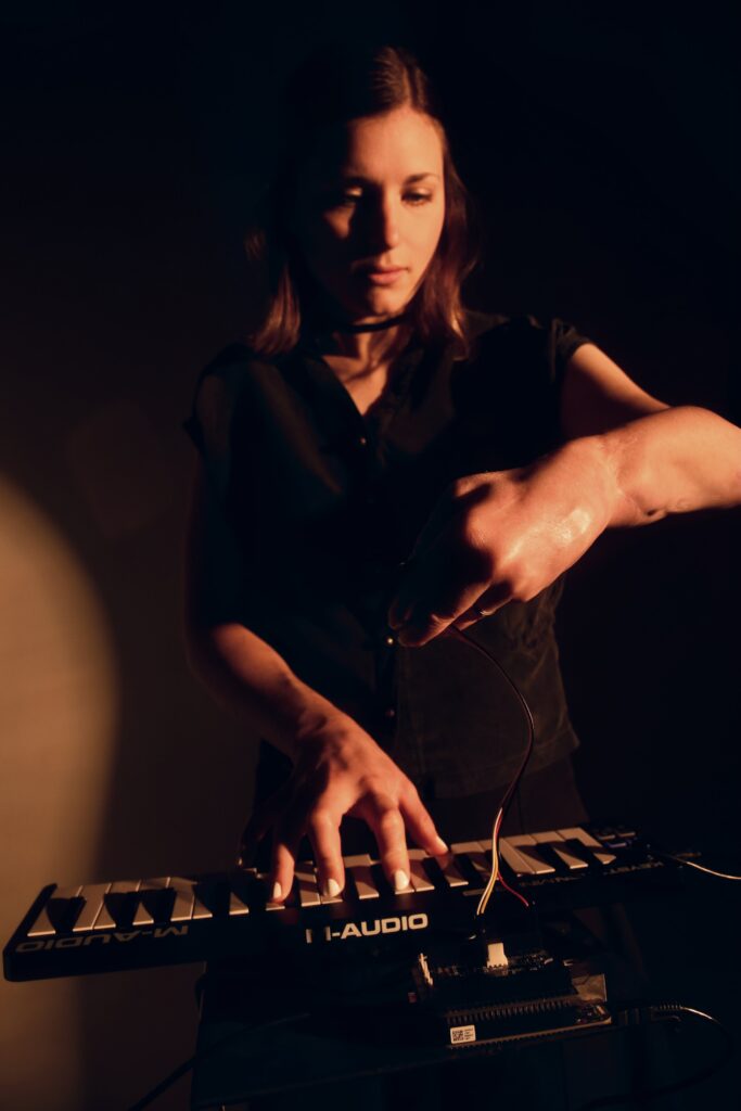 Woman standing behind keyboard with an arm in front of her