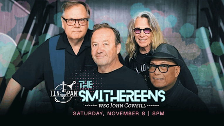 Four members of the rock band, The Smithereens, smile at the camera. Text on the image indicates that they will be playing at the Tin Pan with John Cowsill on Saturday, November 8, at 8 PM.