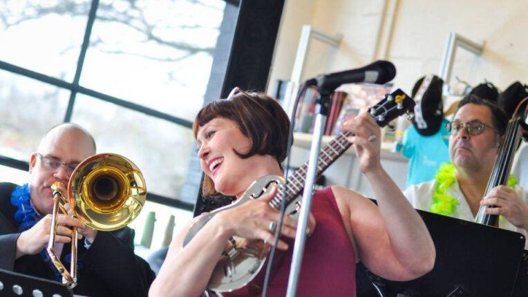 Musical group with female holding ukelele bent backwards