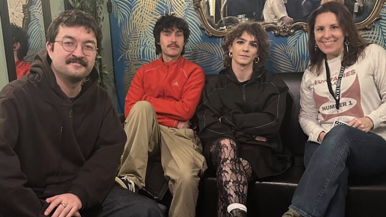 Three members of rock band Gurriers sit with their feet up with DJ Fontana Mercury sitting to the right of them.