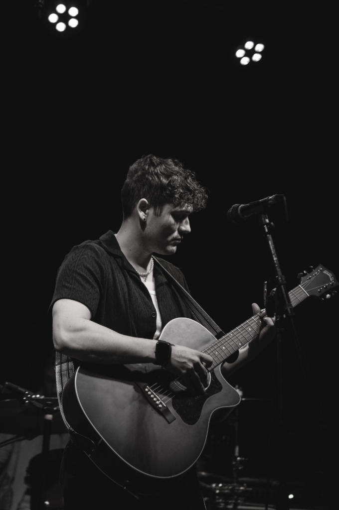 a person playing an acoustic guitar on stage