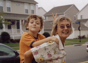 CD cover of a woman with a child on her back on a neighborhood street