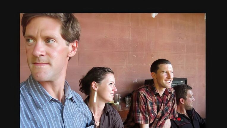 Four people against wall with one staring to left, two to right and one straight ahead