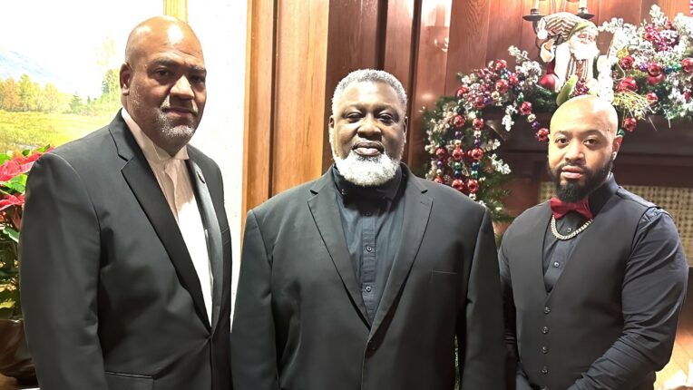 Three men standing in suits