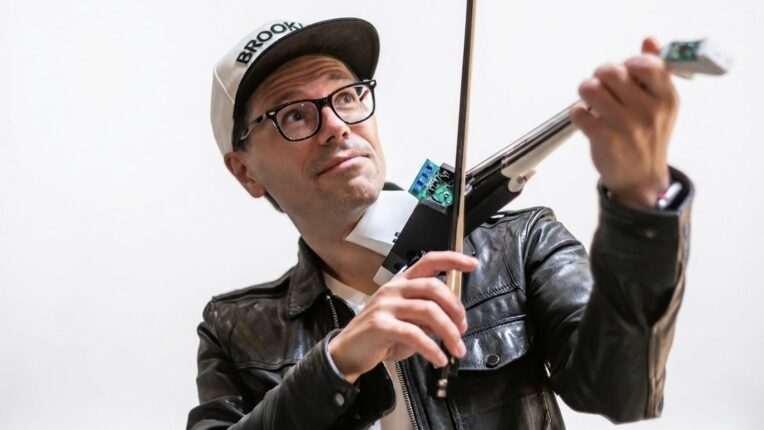 Brian Lindgren, in black leather jacket and baseball hat, plays the electronic viola.