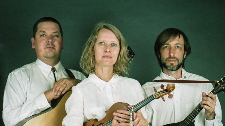Three musicians holding traditional bluegrass instruments