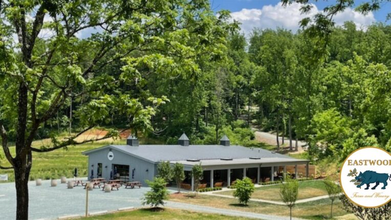 Image of winery from a distance with the logo in the boar bottom right corner.