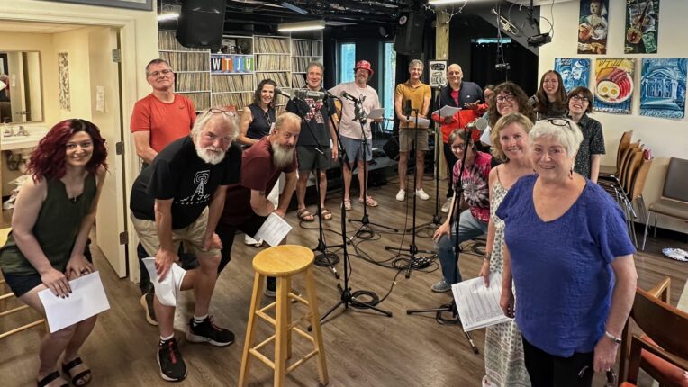 A group of WTJU DJs stand in a semi circle, smiling at the camera