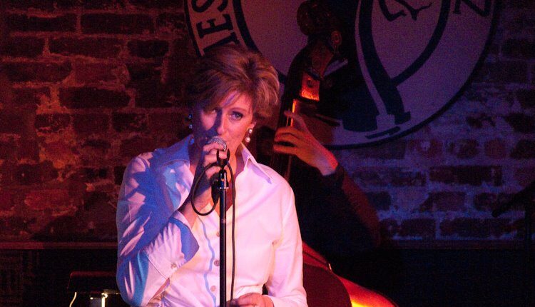 Dutch jazz vocalist Paulien on a stage singing in to a microphone