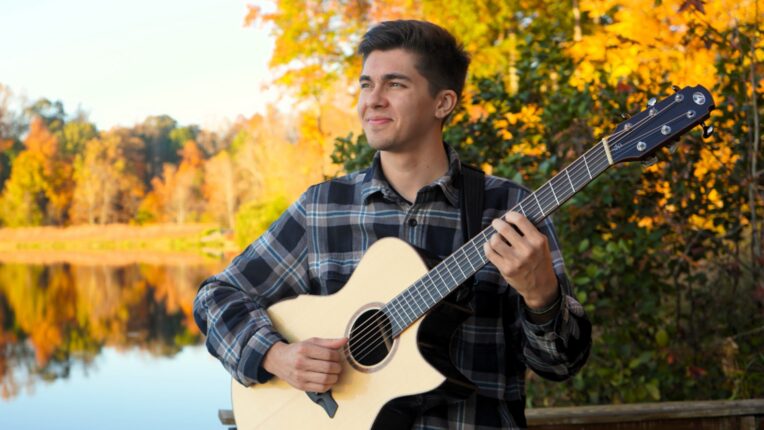 Man holding acoustic guitar.